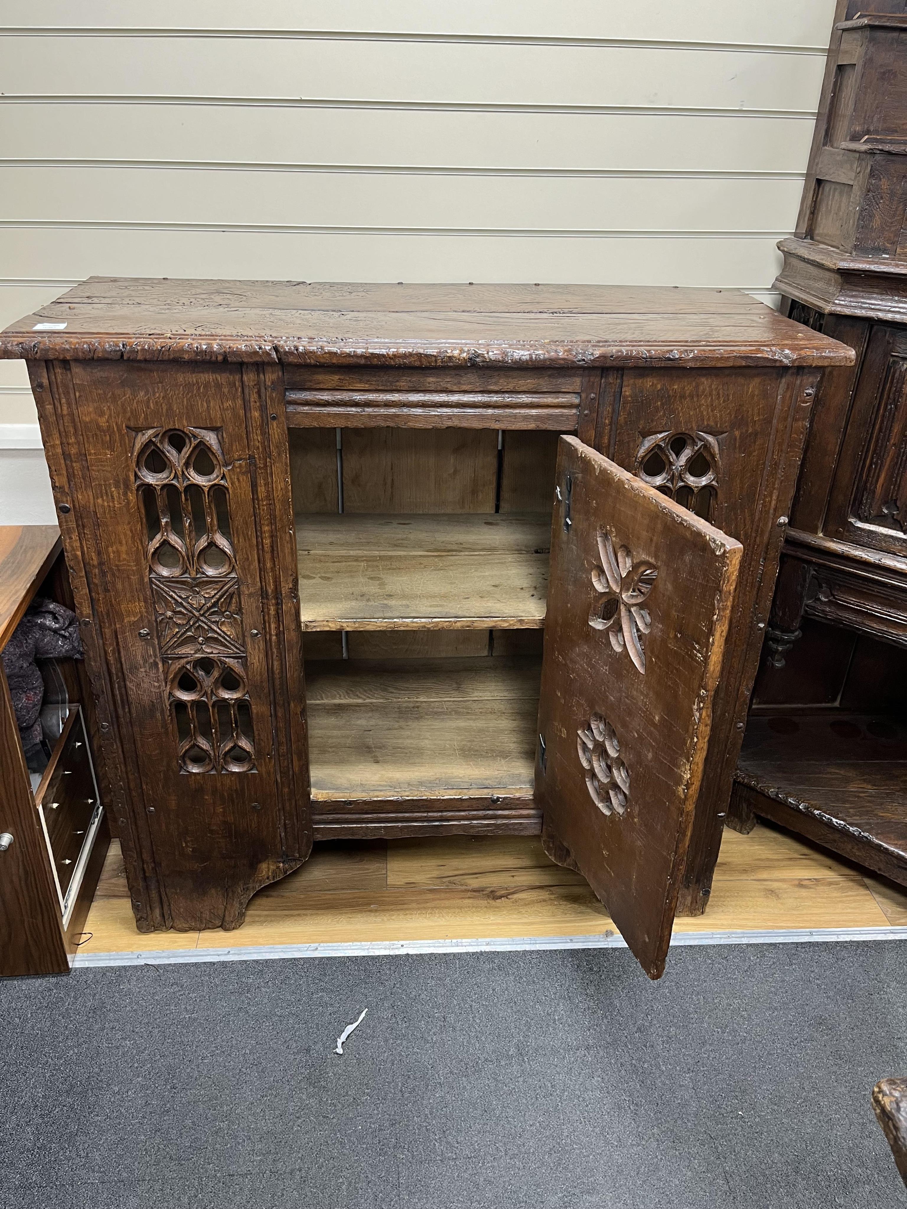 A Gothic boarded oak aumbry, with pierced fretwork panels, in late 15th century style, width 119cm, depth 54cm, height 114cm. Condition - good, Provenance - made for Brede Place, Brede, Rye, East Sussex. Commissioned fro